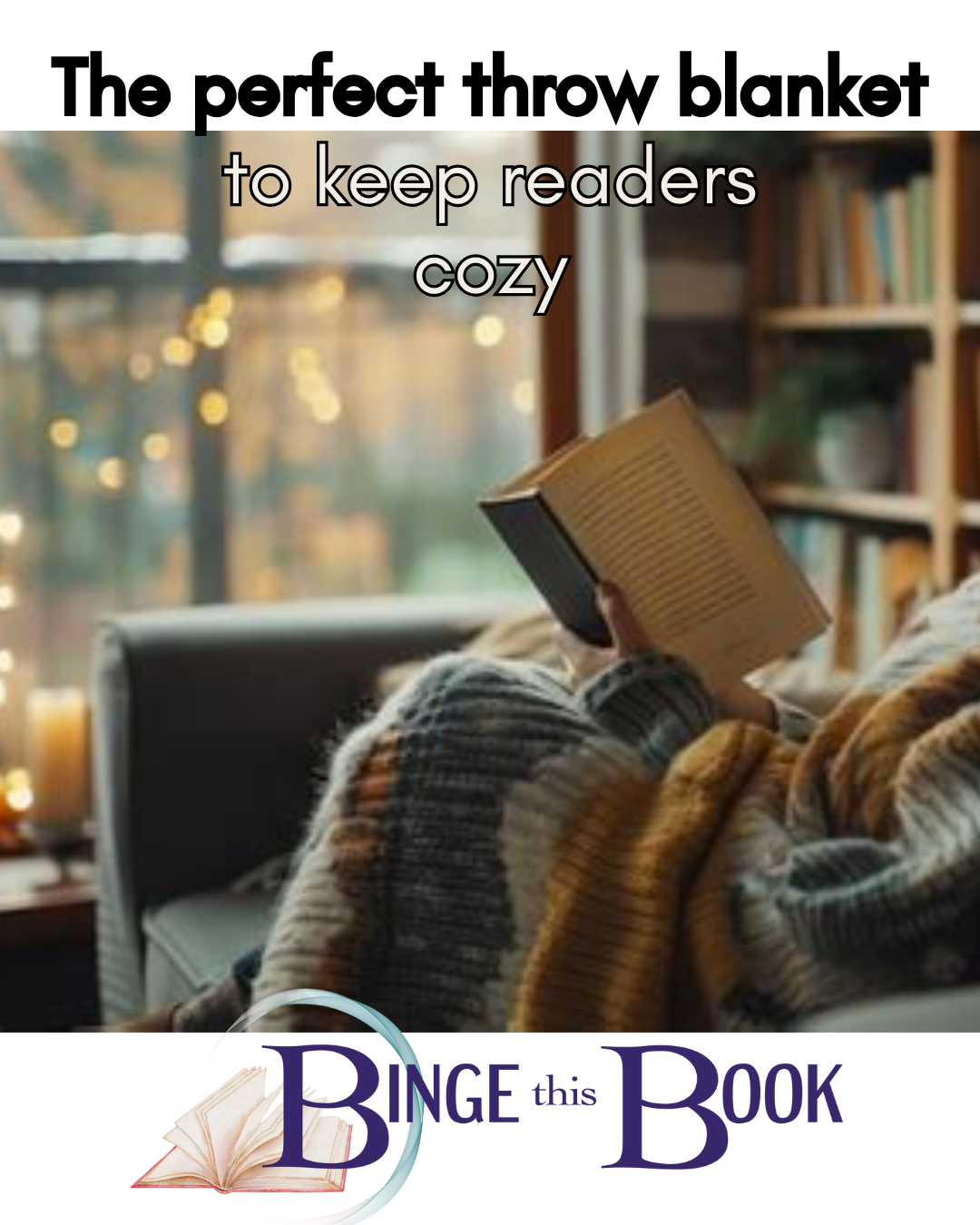 image of a hand holding a book. the person is wrapped in a thick, comfy blanket in front of a full bookshelf and a window